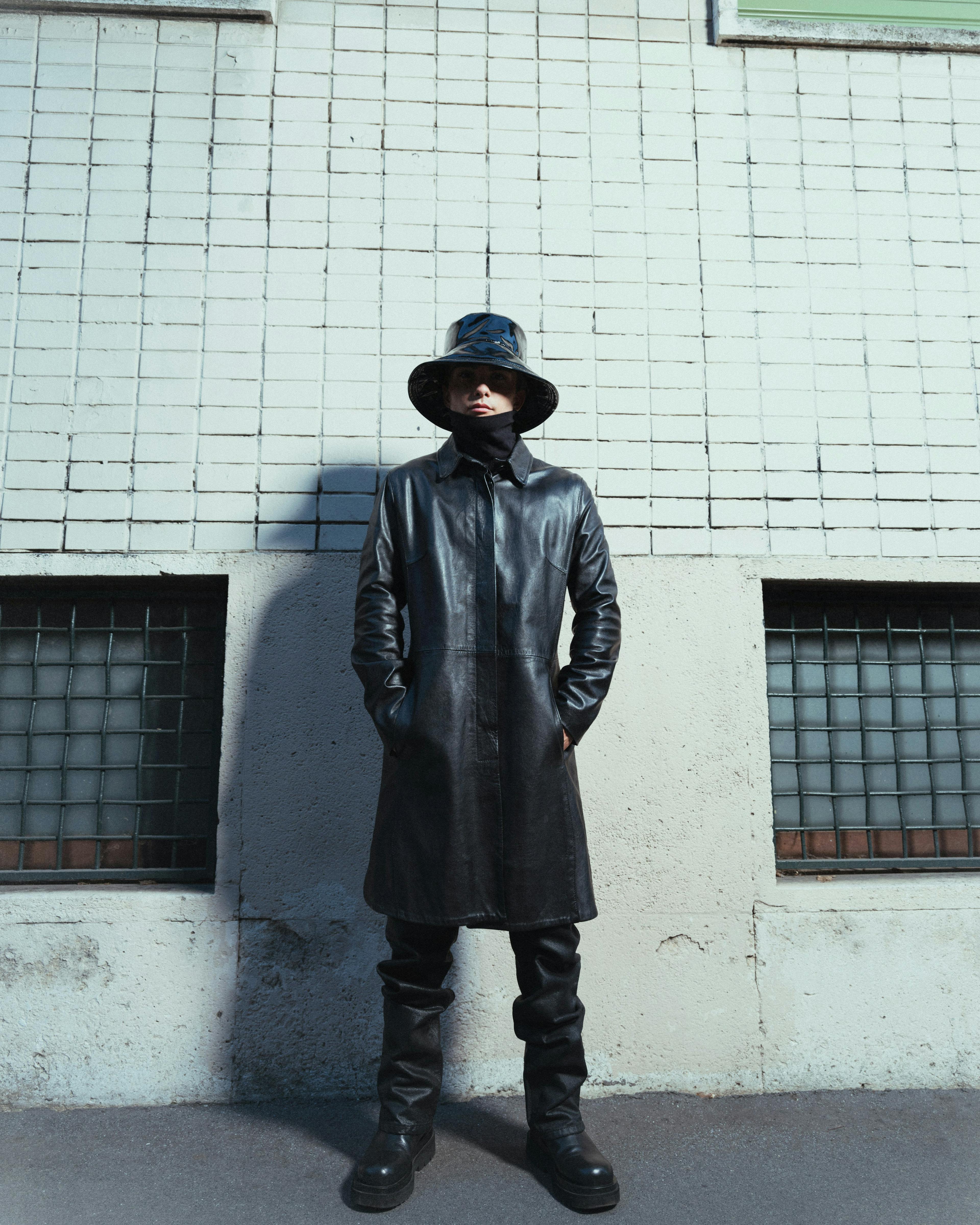 clothing apparel overcoat coat hat person human wall